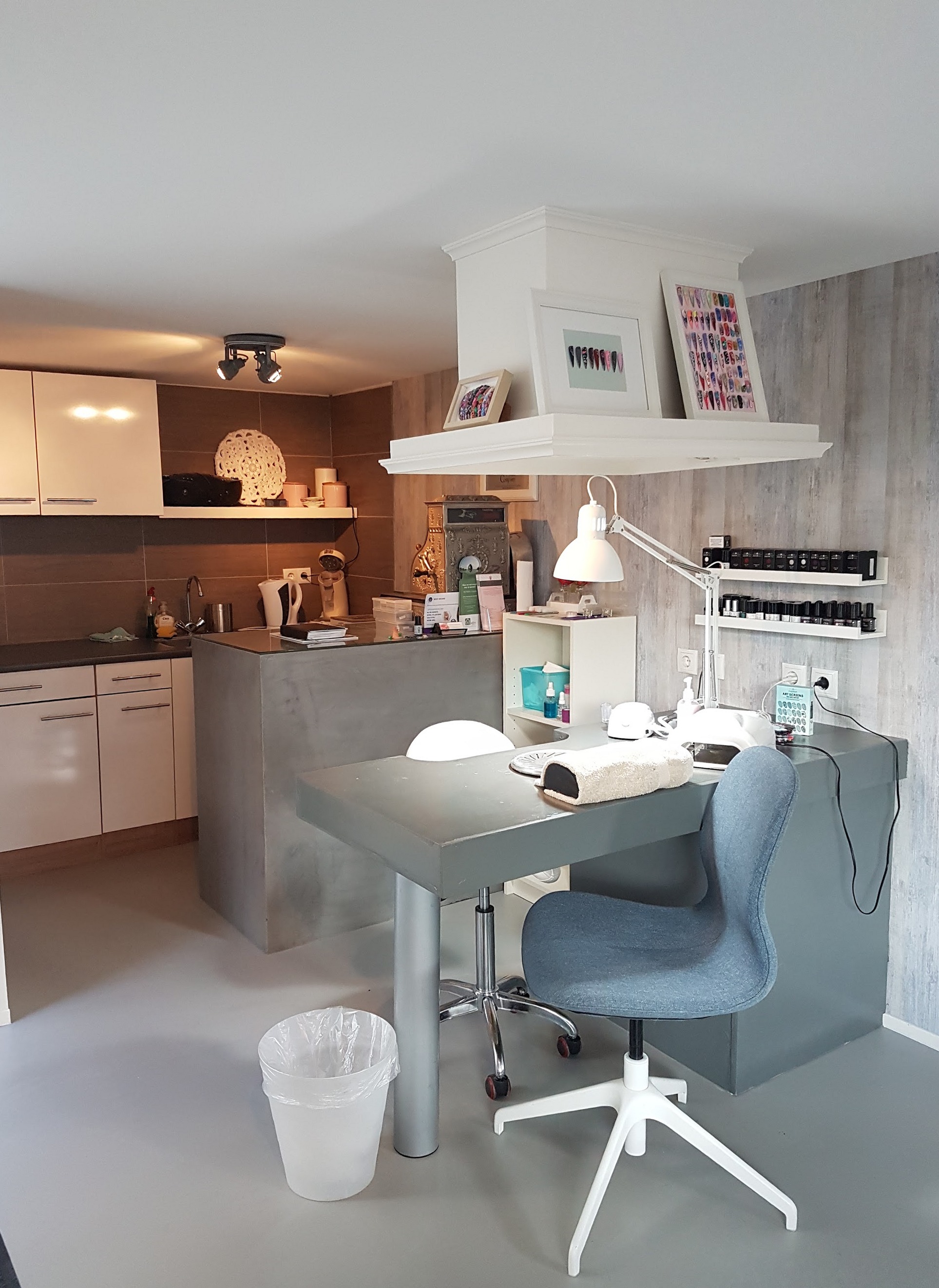 De nageltafel met lamp, stoel en nagellak in de salon