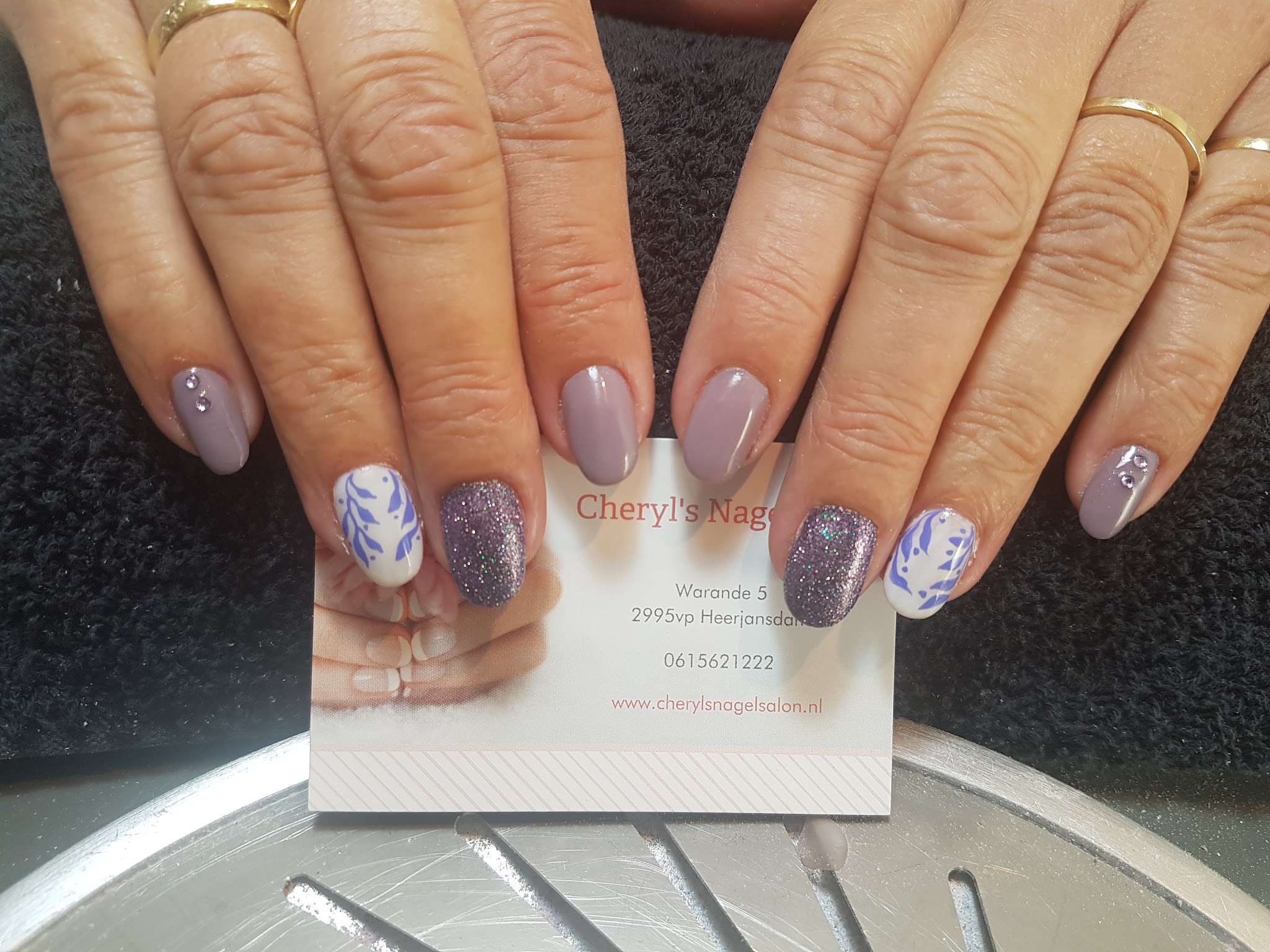 Afgewerkte nagels met zachte paarstinten, glitters en lichte versieringen