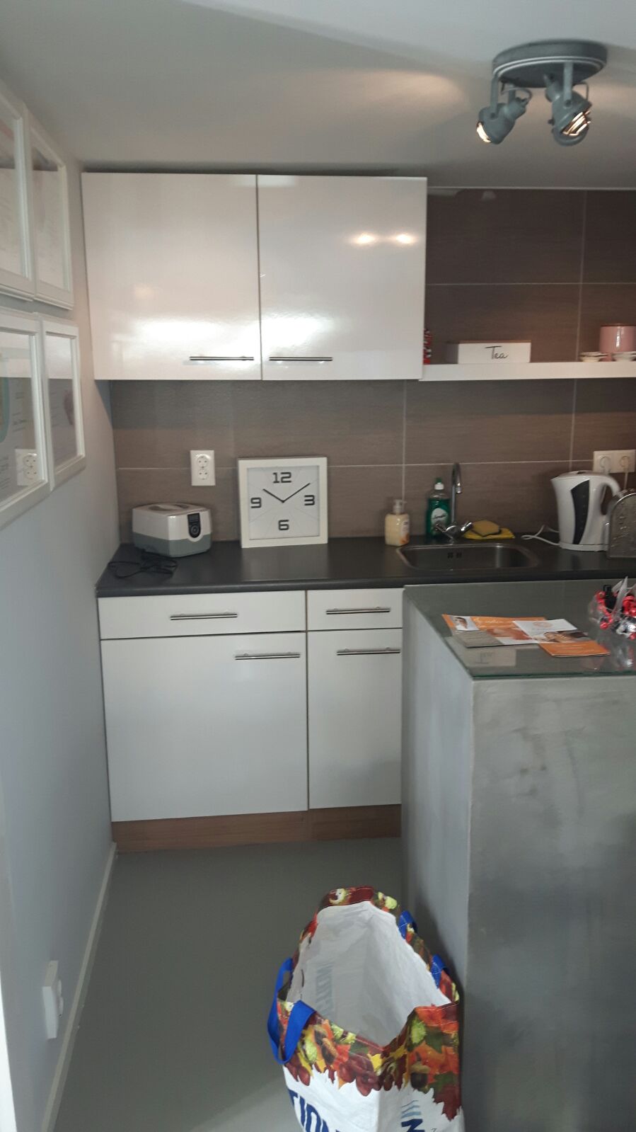 Het interieur van de salon met witte kastjes en een keukenblok